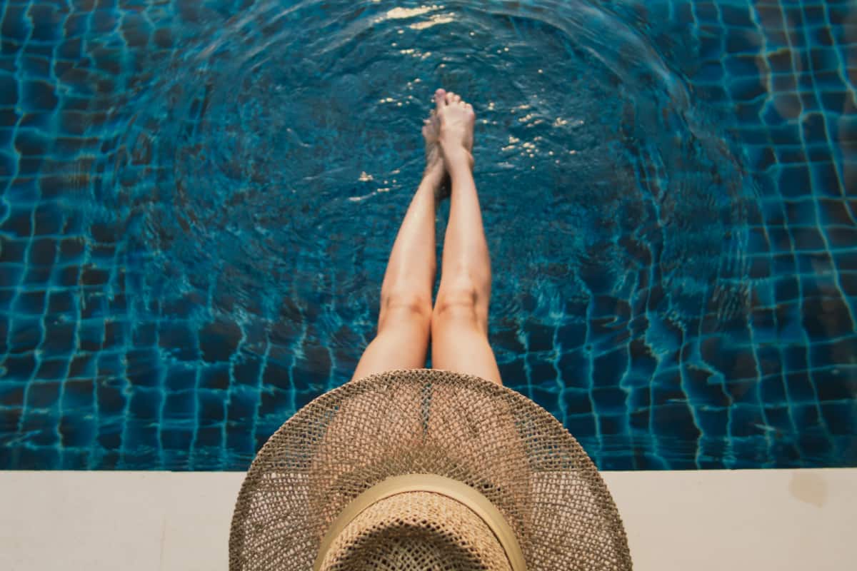 lady in hat by the pool edge lady in hat by the pool edge
