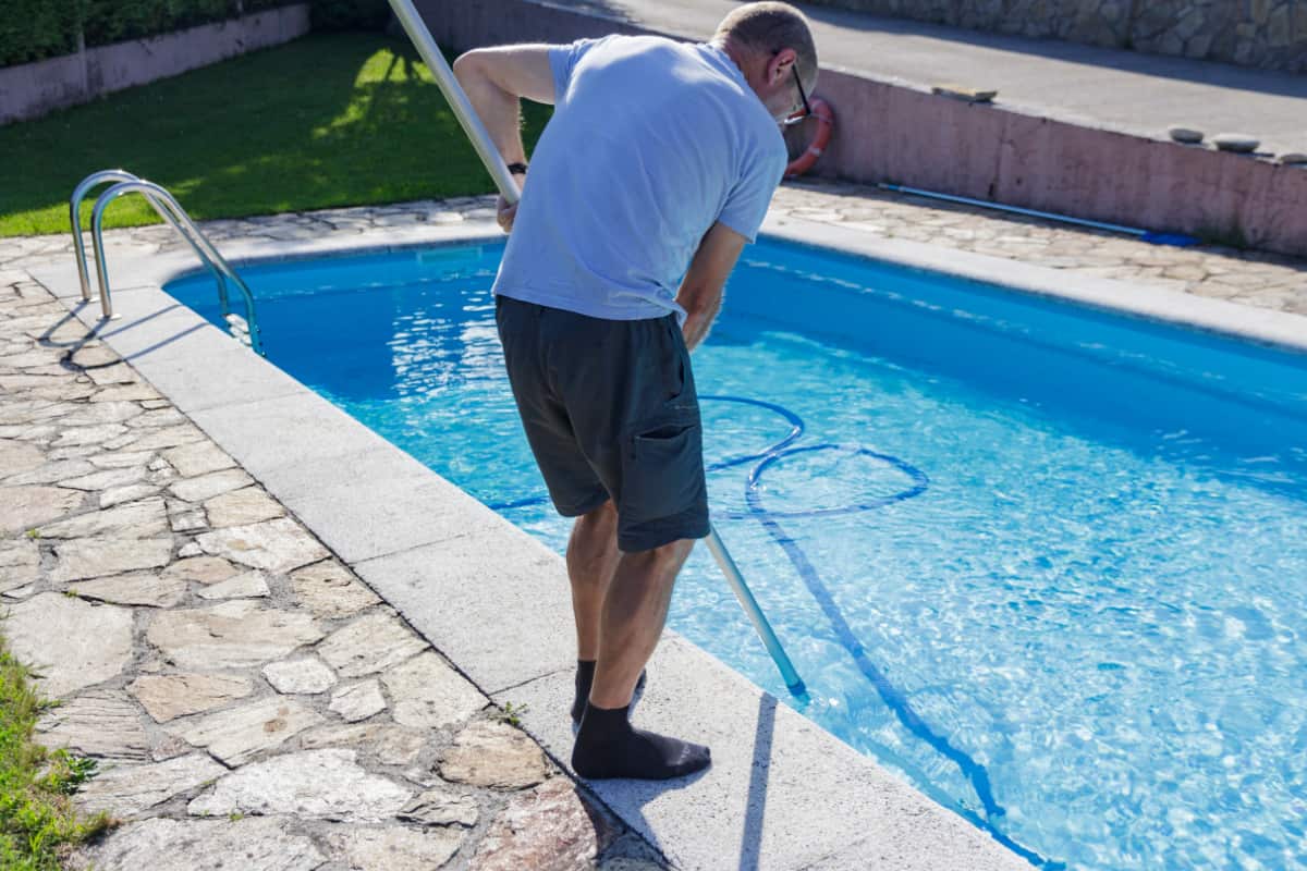 man cleaning swimming pool